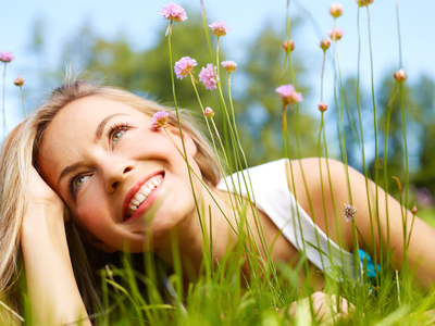 Attractive girl dreaming in a grass with flowers